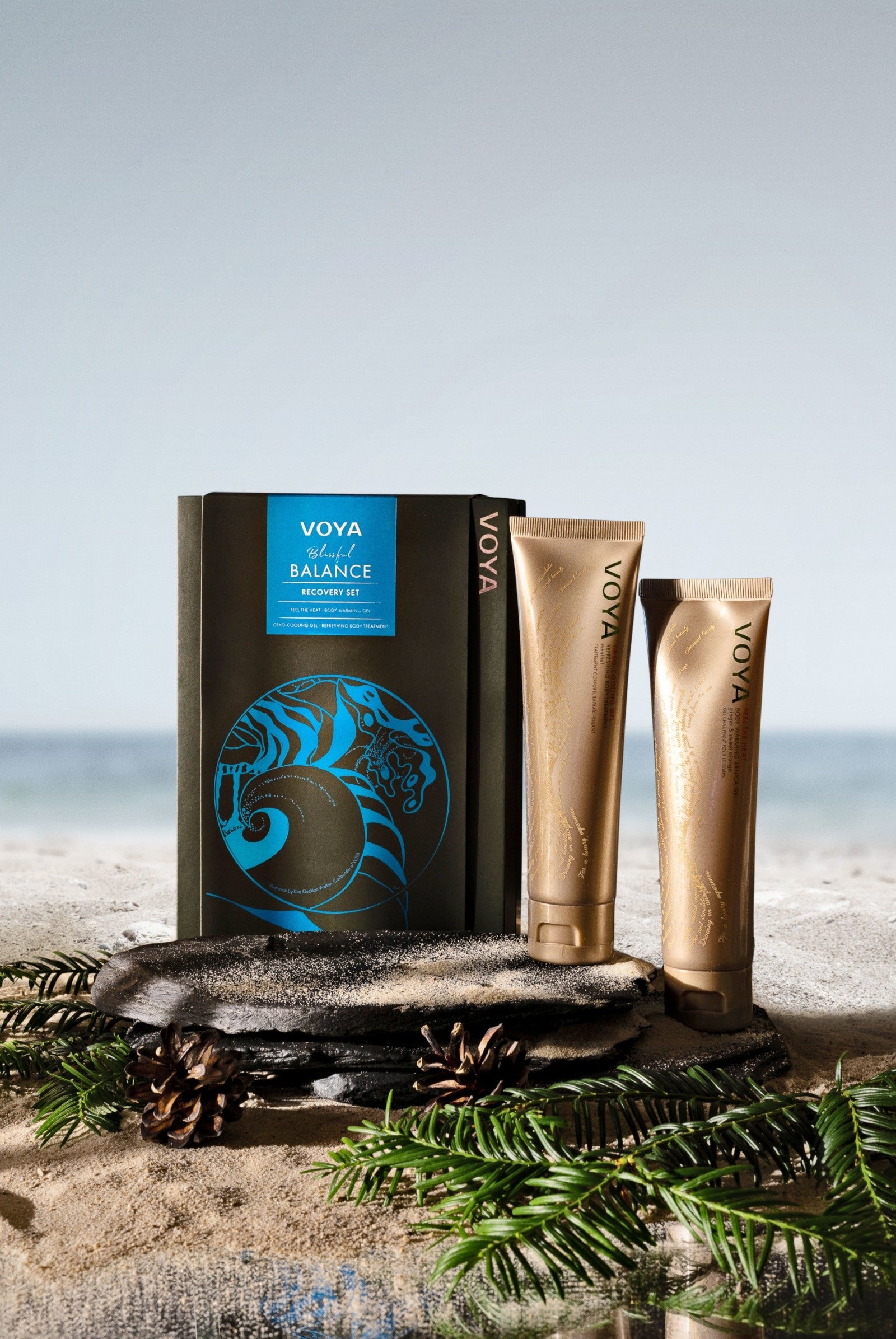 VOYA Blissful Balance Recovery Set featuring Feel the Heat Body Warming Gel and Cryo-Cooling Gel against a beach background. 
