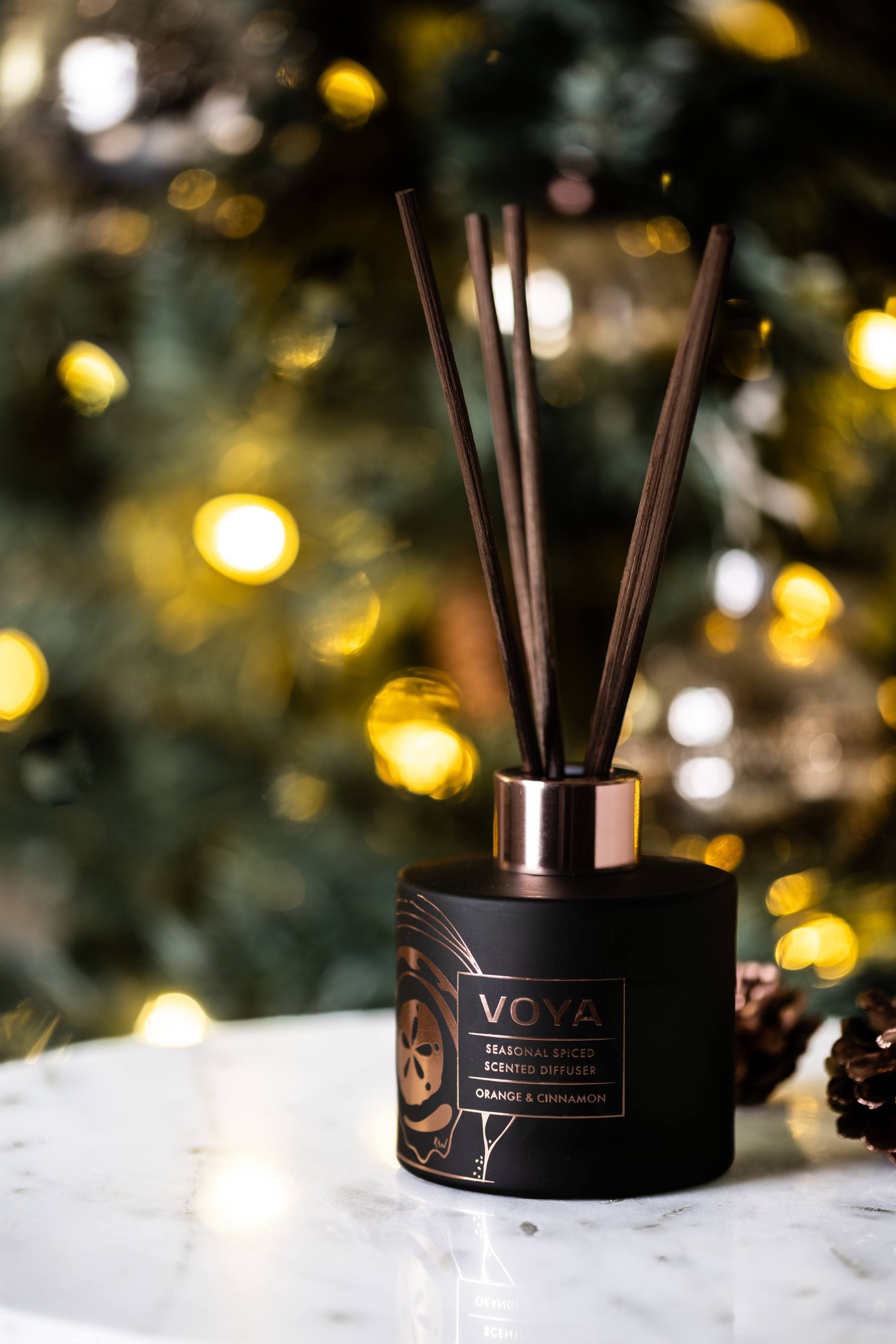 VOYA Seasonal Spiced Christmas Reed Diffuser in front of Christmas tree