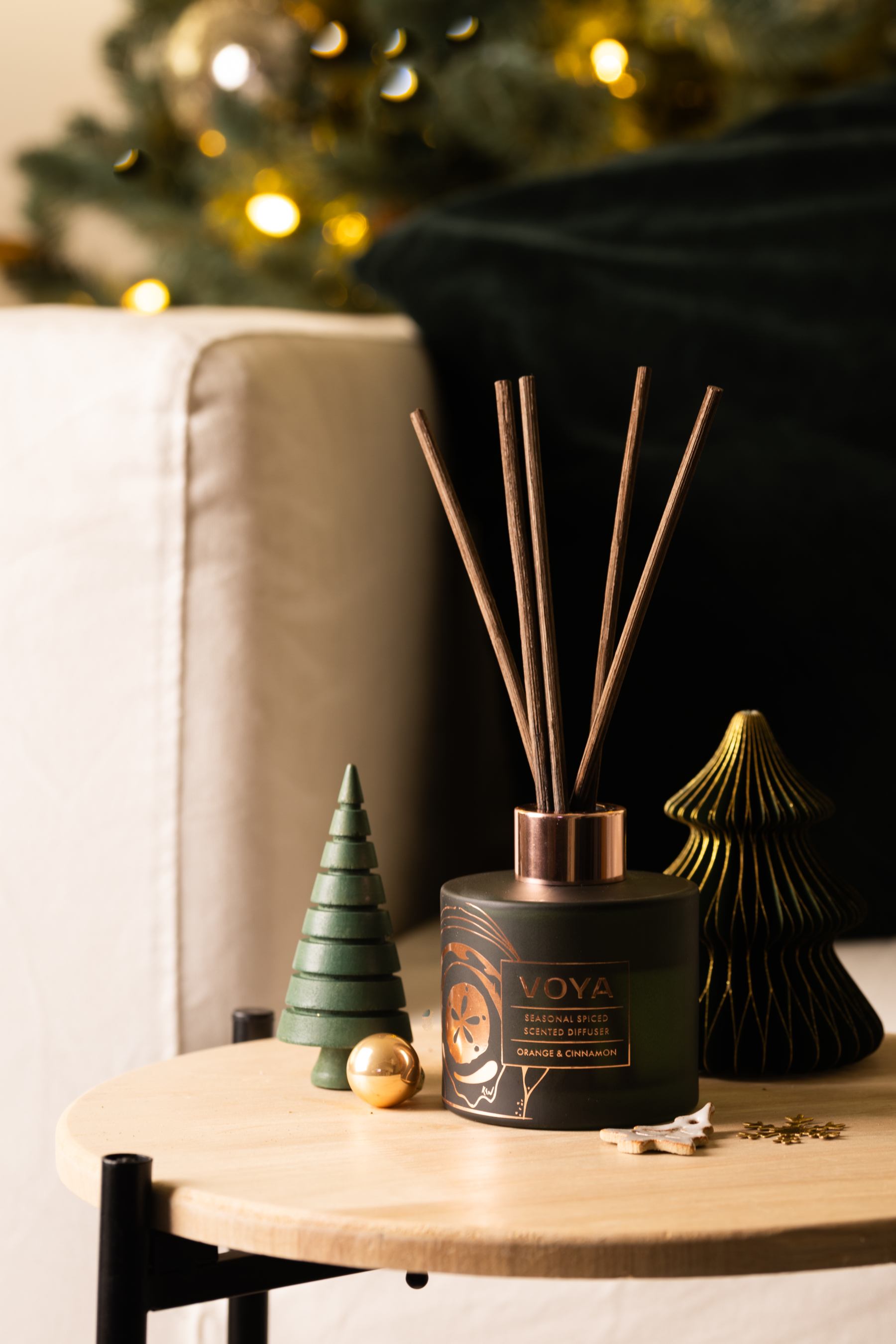 VOYA Seasonal Spiced Christmas Reed Diffuser on table with Christmas ornaments. 