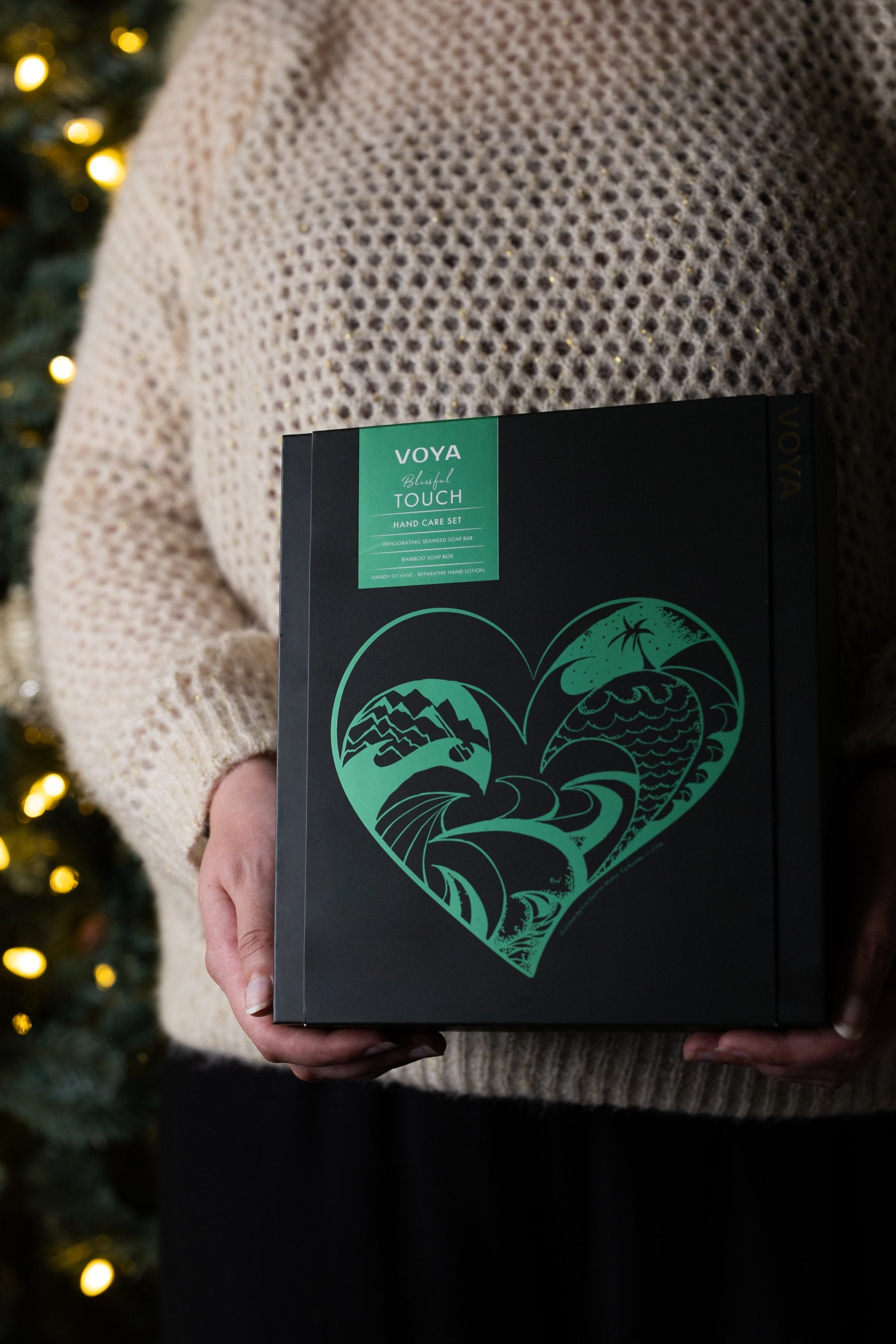 VOYA Hand Renewal Set being held in front of a Christmas tree.